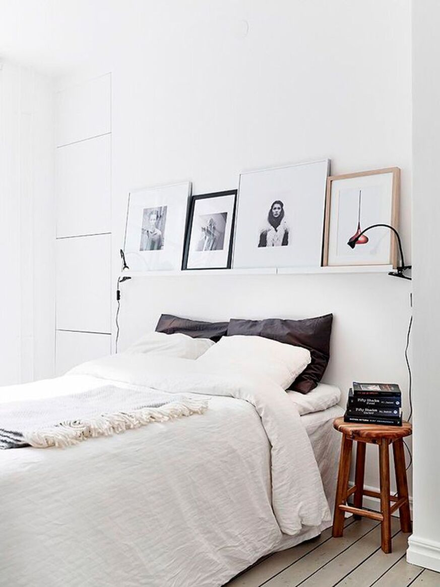 Dormitorio moderno que tiene una cama sin cabecero que tiene cuatro cuadros sobre la pared de la cama